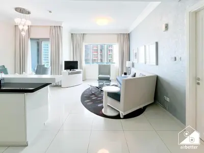 a large white room with a table and chairs at Luxury Living Skyline Views l 2BR with Pool & Gym in Dubai