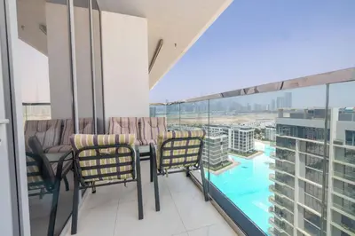 a balcony with chairs and a view of a pool at Modern & Luxurious 2BR Penthouse in MBR City District One Dubai in Dubai