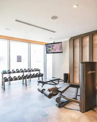 a gym with a row of dumbbells and a screen at The Opera Grand Ultra Luxury Suite Burj Khalifa and Fountain View in Dubai