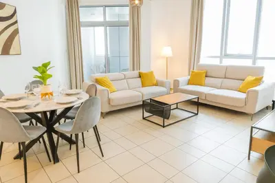 a living room with a couch and a table at Marina 2BR 58th Floor Sea and City Views Pool Gym in Dubai
