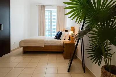 a bedroom with a bed and a potted plant at Marina 2BR 58th Floor Sea and City Views Pool Gym in Dubai