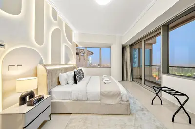 a bedroom with a bed and large windows at Elegant 2BR with Panoramic Marina View in Dubai