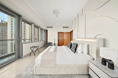 a bedroom with a large bed and large windows at Elegant 2BR with Panoramic Marina View in Dubai