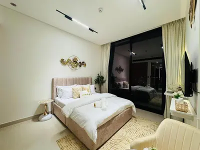 a bedroom with a large bed and a couch at Luxury Studio in JVC Near Marina & Downtown in Dubai