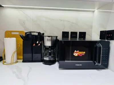 a kitchen counter with a microwave and a coffee maker at Luxury Studio in JVC Near Marina & Downtown in Dubai