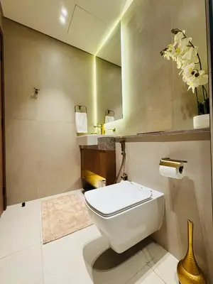 a bathroom with a white toilet and a mirror at Luxury Studio in JVC Near Marina & Downtown in Dubai