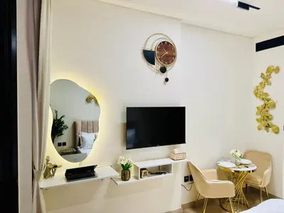 a living room with a tv and a mirror at Luxury Studio in JVC Near Marina & Downtown in Dubai