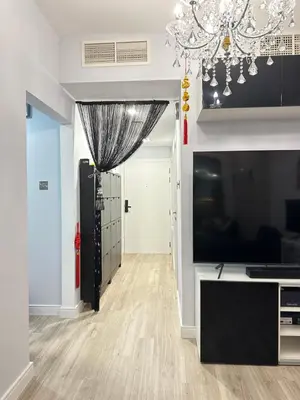 a living room with a television and a chandelier at JLT Luxury New 2BHK in Dubai