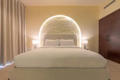 a bedroom with a large white bed with an arch above it at Grand 1bhk burj khalifa view Downtown in Dubai