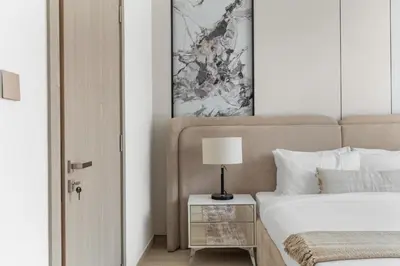 a bedroom with a bed and a table with a lamp at Luxury 4BR Villa Free Malibu Beach Access in Dubai