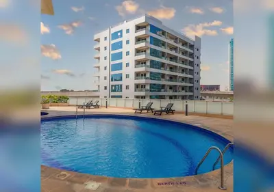 a large building with a swimming pool in front of a building at Comfort Ensuite with Balcony in Dubai