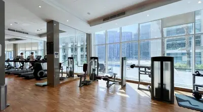 an empty gym with a view of the city at Poolside Studio with Canal Views and Near Dubai Mall in Dubai