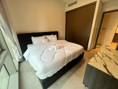 a bedroom with a bed with white sheets and pillows at Grande in Dubai
