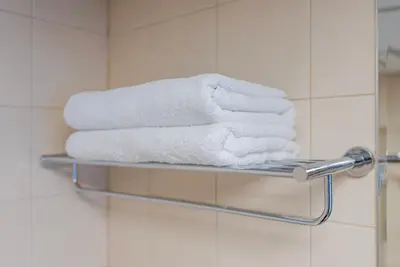 a stack of towels on a towel rack in a bathroom at Bright 1bhk Full Marina View in Dubai