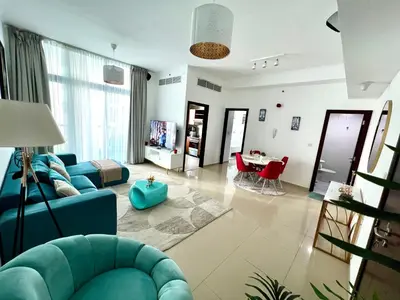 a living room with a blue couch and a table at Stylish 1-Bedroom Apartment in the Heart of Dubai Marina in Dubai