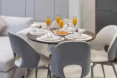 a dining room with a table with chairs and drinks at Deluxe Nobles Suites by Hostiva - Garden View in Dubai