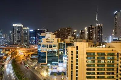 a city skyline at night with buildings and traffic at 1BR Apartment with Private Jacuzzi & Burj Khalifa Skyline in Trillionaire Residences By Binghatti in Dubai