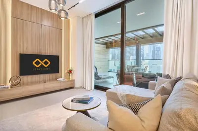 a living room with a couch and a tv at 1BR Apartment with Private Jacuzzi & Burj Khalifa Skyline in Trillionaire Residences By Binghatti in Dubai