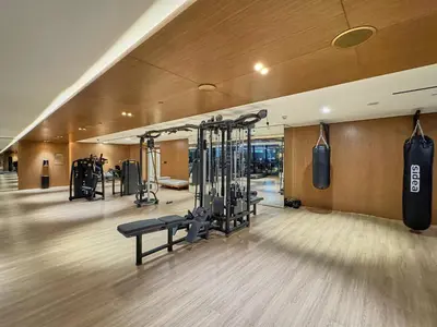 a gym with lots of gym equipment in a building at 1BR Apartment with Private Jacuzzi & Burj Khalifa Skyline in Trillionaire Residences By Binghatti in Dubai