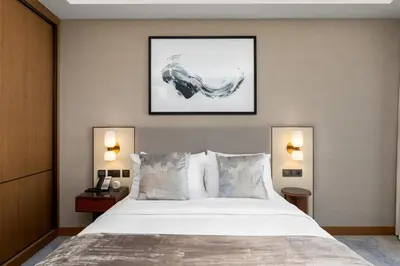 a bedroom with a large white bed with two lamps at Maison Privee - Fabulous Apt with Sensational Burj Khalifa Views in Dubai
