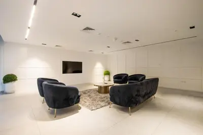 a waiting room with chairs and a table and a tv at 1BR Paragon Tower Burj Khalifa & Canal Views in Dubai