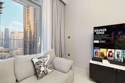 a living room with a couch and a large window at Luxury 4BR Burj Khalifa Dubai Mall in Dubai