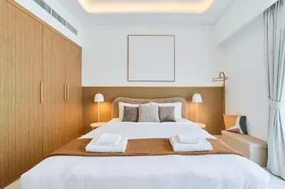 a bedroom with a large bed with two towels on it at Modern & Elegant Studio Apartment in Azizi Riviera in Dubai