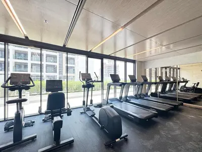 a gym with a row of treadms and cardio machines at Modern & Elegant Studio Apartment in Azizi Riviera in Dubai