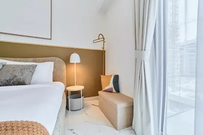 a bedroom with a bed and a chair and a window at Modern & Elegant Studio Apartment in Azizi Riviera in Dubai