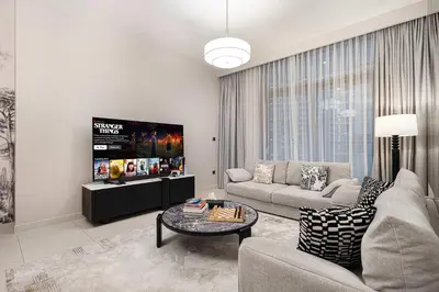 a living room with a couch and a tv at Luxury 4BR Burj Khalifa Opera District in Dubai