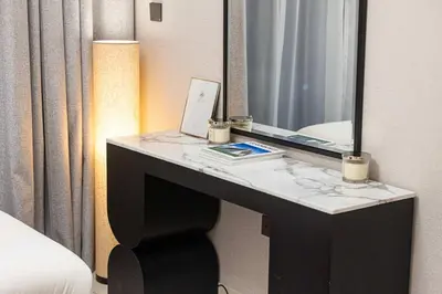 a desk in a hotel room with a mirror and a laptop at Luxury 4BR Burj Khalifa Opera District in Dubai