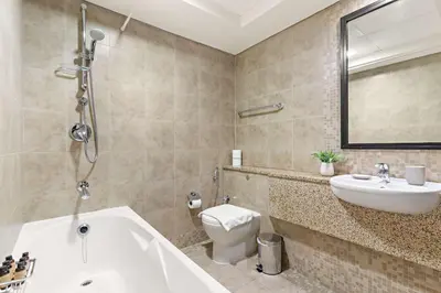 a bathroom with a tub and a sink and a toilet at Silkhaus Modern Studio in Sky Gardens Tower DIFC in Dubai