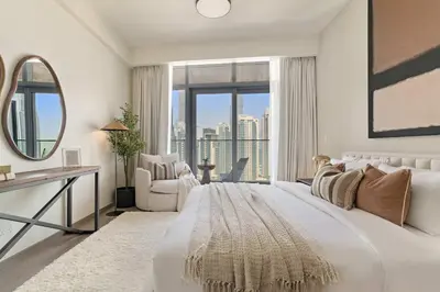 a white bedroom with a large bed with a large window at Silkhaus Lavish 3BDR+Maid Room Imperial Avenue in Dubai