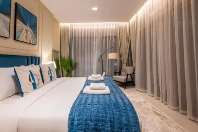 a bedroom with a large white bed with a blue blanket at Modern 1 bedroom with Direct Marina Access in Dubai