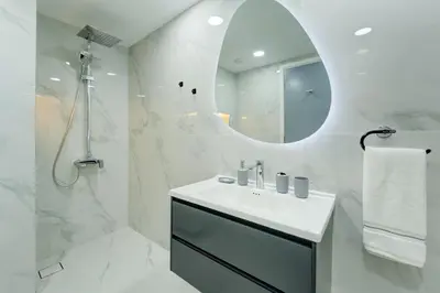 a white bathroom with a sink and a mirror at Souk Al Bahar Lavish 1-bedroom apartment with Burj Khalifa view at your doorstep by Norbu Holiday Homes in Dubai