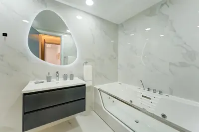 a white bathroom with a sink and a mirror at Souk Al Bahar Lavish 1-bedroom apartment with Burj Khalifa view at your doorstep by Norbu Holiday Homes in Dubai