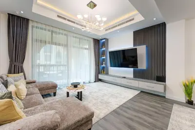 a living room with a couch and a tv at Souk Al Bahar Lavish 1-bedroom apartment with Burj Khalifa view at your doorstep by Norbu Holiday Homes in Dubai