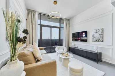 a living room with a couch and a tv at Modern 2BR in Ikarus Tower, Dubai Production City in Dubai