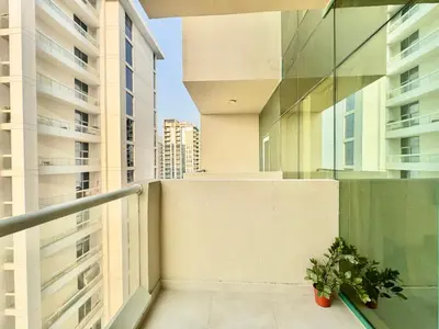 a balcony with a plant and some buildings at Homes2Retreat - Cozy Studio with Pool and Sauna in Al Furjan in Dubai