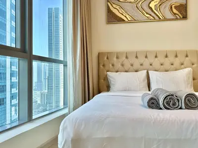 a bedroom with a white bed with a large window at New Modern Marina View Apartment in Bay Central in Dubai