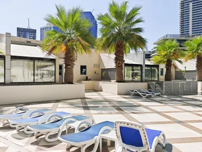 a patio with chairs and palm trees and buildings at New Modern Marina View Apartment in Bay Central in Dubai