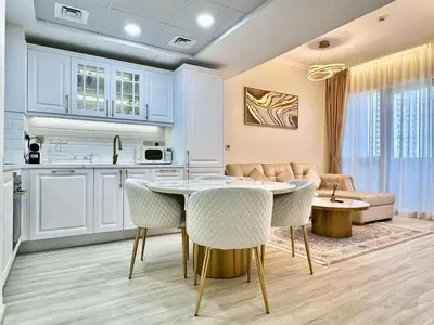 a kitchen and living room with a table and chairs at New Modern Marina View Apartment in Bay Central in Dubai