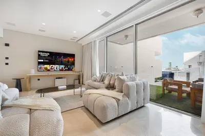 a living room with two chairs and a tv at Five Palm Jumeirah Luxury Apartment - 3BR in Dubai