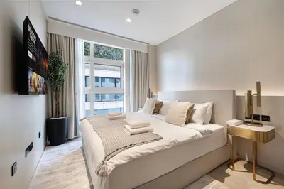 a white bedroom with a large bed and a window at Five Palm Jumeirah Luxury Apartment - 3BR in Dubai
