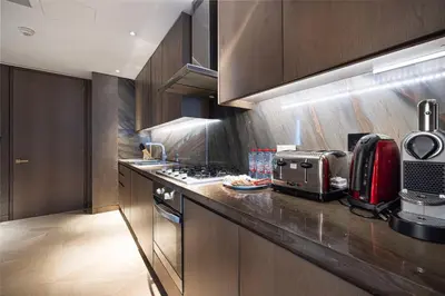 a kitchen with wooden cabinets and a counter top at Five Palm Jumeirah Luxury Apartment - 3BR in Dubai