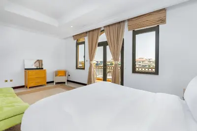 a white bedroom with a large bed and windows at Palm Villa F, Palm Jumeirah - Mint Stay in Dubai