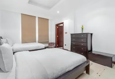 a white bedroom with two beds and a dresser at Palm Villa F, Palm Jumeirah - Mint Stay in Dubai