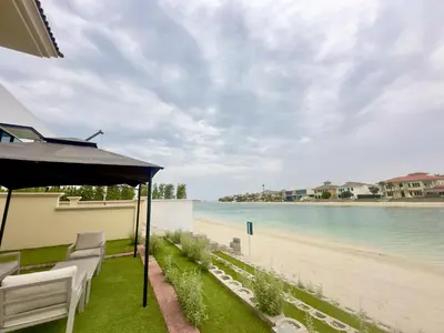 a view of a beach with chairs and an umbrella at Palm Villa F, Palm Jumeirah - Mint Stay in Dubai