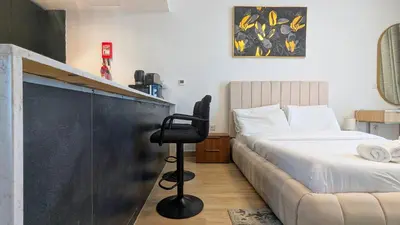 a bedroom with a bed and a desk with a chair at Modern Apartment in Regina Tower JVC - Easy Access to JBR, Circle Mall & Dubai Hills Mall in Dubai