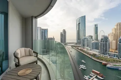 a balcony with a chair and a view of a city at BLVD - Direct Marina Walk - Eye of Dubai Fireworks - Iconic Marina Views with Rooftop Pool in Dubai